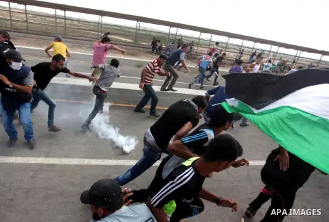 Palestinian protesters clash with Israeli security forces next to the border fence with Israel, at the Erez crossing in the northern Gaza strip, on October 13, 2015. A wave of stabbings that hit Israel, Jerusalem and the...