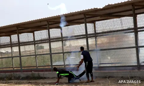 A Palestinian protester throws back a tear gas canister during clashes with Israeli security forces next to the border fence with Israel, at the Erez crossing in the northern Gaza strip, on October 13, 2015. A wave of st...
