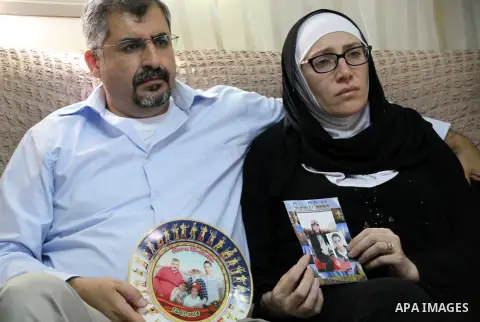 The parents of the 18-year-old Palestinian Mustafa al-Khatib, who was killed by Israeli security forces, hold his pictures at their house in Jabal al-Mukaber neighborhood, southern Jerusalem, on October 13, 2015. A wave...