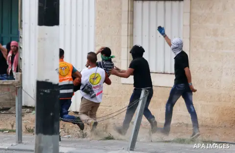Palestinian protesters carry an injured comrade during clashes with Israeli security forces in the West Bank city of Bethlehem, on October 13, 2015. A wave of stabbings that hit Israel, Jerusalem and the West Bank this m...