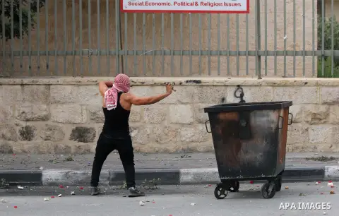 A Palestinian protester uses a sling shot to throw stones at Israeli security forces during clashes in the West Bank city of Bethlehem, on October 13, 2015. A wave of stabbings that hit Israel, Jerusalem and the West Ban...