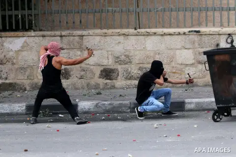 Palestinian protesters use sling shots to throw stones at Israeli security forces during clashes in the West Bank city of Bethlehem, on October 13, 2015. A wave of stabbings that hit Israel, Jerusalem and the West Bank t...