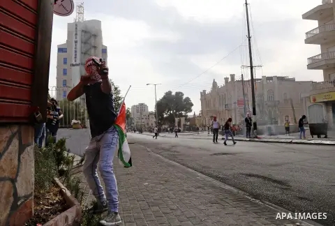 A Palestinian protester uses a sling shot to throw stones at Israeli security forces during clashes in the West Bank city of Bethlehem, on October 13, 2015. A wave of stabbings that hit Israel, Jerusalem and the West Ban...