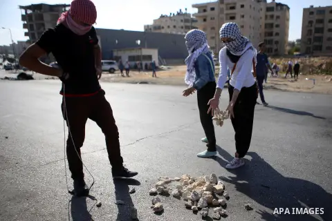 Palestinian female protesters gather stones during clashes with Israeli security forces near the Jewish settlement of Bet El, near the West Bank city of Ramallah, on October 14, 2015. Seven Israelis and 30 Palestinians,...