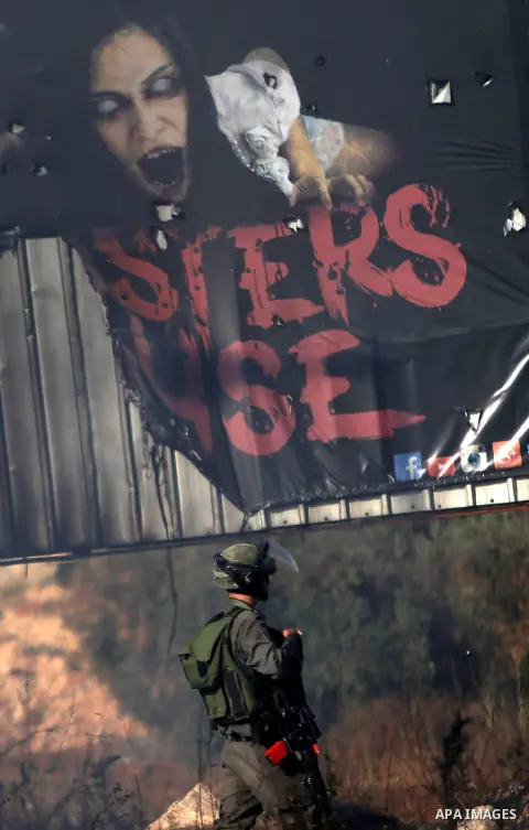 An Israeli soldier take position during clashes with Palestinian protesters near the Jewish settlement of Bet El, near the West Bank city of Ramallah, on October 14, 2015. Seven Israelis and 30 Palestinians, including ch...