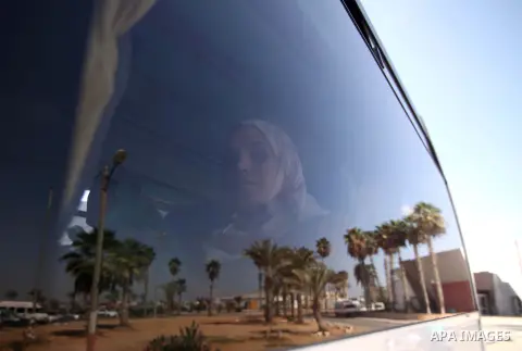 A Palestinian woman sits in a bus as she returns to Gaza, at the Rafah border crossing between Egypt and southern Gaza Strip October 15, 2015. Egypt opened the Rafah border crossing on Thursday for one day to allow stran...