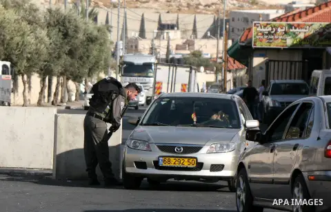 An Israeli policeman inspects cars in a street in Jerusalem's Old city on October 15, 2015. Seven Israelis and 30 Palestinians, including children and assailants, have been killed in two weeks of bloodshed in Israel, Jer...