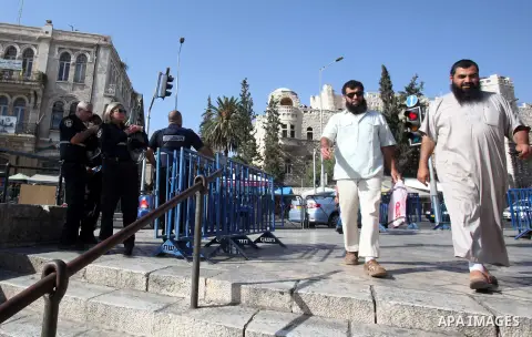 Palestinian men walk past Israeli policemen as they stand guard in a street in Jerusalem's Old city on October 15, 2015. Seven Israelis and 30 Palestinians, including children and assailants, have been killed in two week...