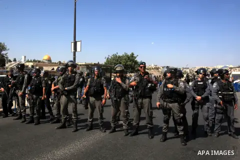 Israeli police stand guard as Palestinian Muslims pray on the streets of the Wadi al-Joz neighbourhood in east Jerusalem during the Friday prayers following restrictions by Israeli police preventing Palestinians under 40...