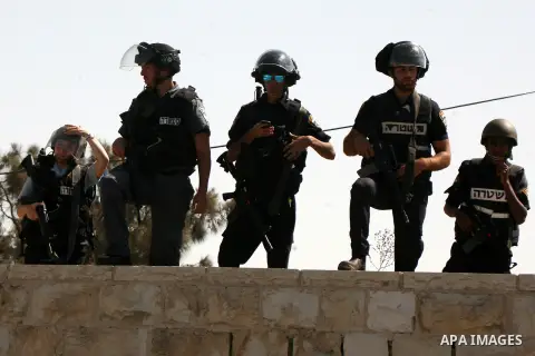 Israeli police stand guard as Palestinian Muslims pray on the streets of the Wadi al-Joz neighbourhood in east Jerusalem during the Friday prayers following restrictions by Israeli police preventing Palestinians under 40...