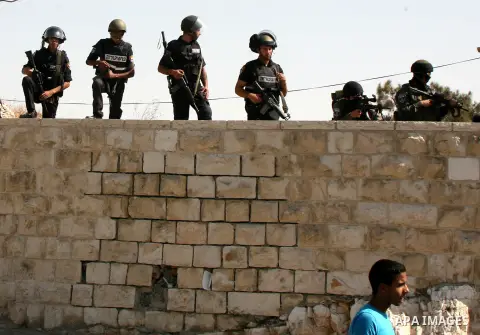 Israeli police stand guard as Palestinian Muslims pray on the streets of the Wadi al-Joz neighbourhood in east Jerusalem during the Friday prayers following restrictions by Israeli police preventing Palestinians under 40...