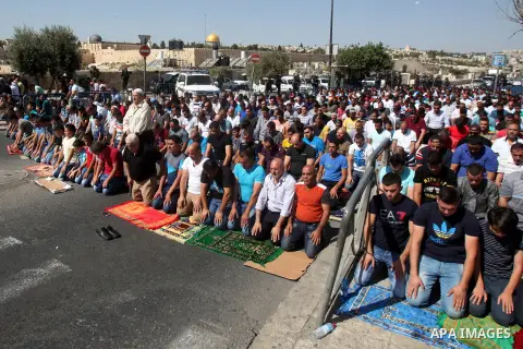 Israeli police stand guard as Palestinian Muslims pray on the streets of the Wadi al-Joz neighbourhood in east Jerusalem during the Friday prayers following restrictions by Israeli police preventing Palestinians under 40...