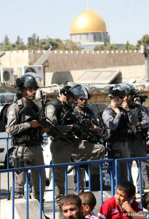 Israeli police stand guard as Palestinian Muslims pray on the streets of the Wadi al-Joz neighbourhood in east Jerusalem during the Friday prayers following restrictions by Israeli police preventing Palestinians under 40...