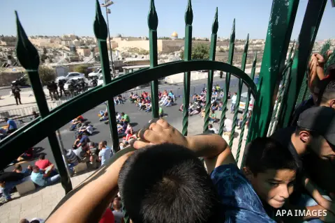 Israeli police stand guard as Palestinian Muslims pray on the streets of the Wadi al-Joz neighbourhood in east Jerusalem during the Friday prayers following restrictions by Israeli police preventing Palestinians under 40...