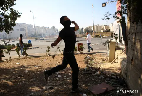 A Palestinian protester throws stones towards Israeli security forces during clashes near the Beit El settlement on the outskirts of Ramallah in the West Bank, on October 16, 2015. The unrest that has engulfed Jerusalem...