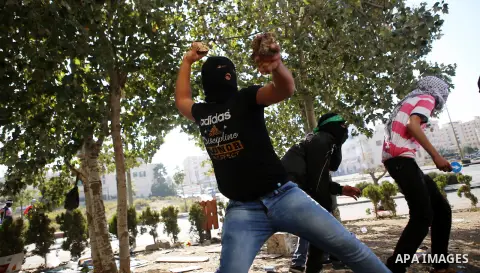Palestinian protesters throw stones towards Israeli security forces during clashes near the Beit El settlement on the outskirts of Ramallah in the West Bank, on October 16, 2015. The unrest that has engulfed Jerusalem an...