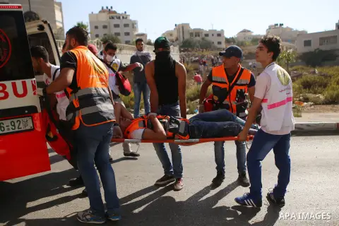 Palestinian medics carry an injured man during clashes with Israeli security forces near the Beit El settlement on the outskirts of Ramallah in the West Bank, on October 16, 2015. The unrest that has engulfed Jerusalem a...