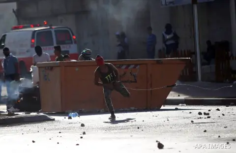 A Palestinian protester throws stones towards Israeli security forces during clashes near the Beit El settlement on the outskirts of Ramallah in the West Bank, on October 16, 2015. The unrest that has engulfed Jerusalem...