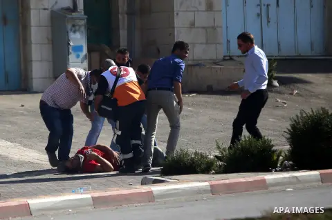 Palestinian medics carry an injured man during clashes with Israeli security forces near the Beit El settlement on the outskirts of Ramallah in the West Bank, on October 16, 2015. The unrest that has engulfed Jerusalem a...