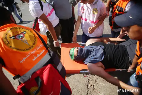 Palestinian medics carry an injured man during clashes with Israeli security forces near the Beit El settlement on the outskirts of Ramallah in the West Bank, on October 16, 2015. The unrest that has engulfed Jerusalem a...