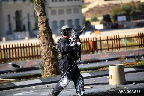 A member of Israeli security forces fires tear gas towards Palestinian protesters during clashes near the Beit El settlement on the outskirts of Ramallah in the West Bank, on October 16, 2015. The unrest that has engulfe...