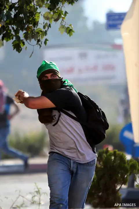 A Palestinian protester throws stones towards Israeli security forces during clashes near the Beit El settlement on the outskirts of Ramallah in the West Bank, on October 16, 2015. The unrest that has engulfed Jerusalem...