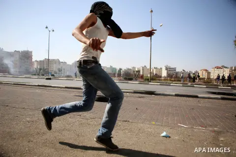 A Palestinian protester throws stones towards Israeli security forces during clashes near the Beit El settlement on the outskirts of Ramallah in the West Bank, on October 16, 2015. The unrest that has engulfed Jerusalem...