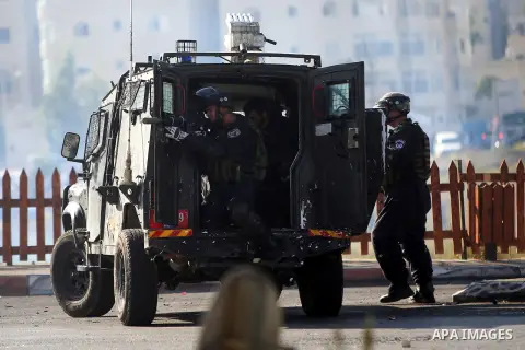 A member of Israeli security forces fires tear gas towards Palestinian protesters during clashes near the Beit El settlement on the outskirts of Ramallah in the West Bank, on October 16, 2015. The unrest that has engulfe...