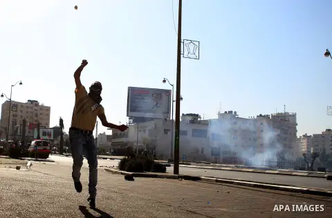 A Palestinian protester throws stones towards Israeli security forces during clashes near the Beit El settlement on the outskirts of Ramallah in the West Bank, on October 16, 2015. The unrest that has engulfed Jerusalem...