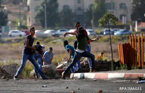 Palestinian protesters throw stones towards Israeli security forces during clashes near the Beit El settlement on the outskirts of Ramallah in the West Bank, on October 16, 2015. The unrest that has engulfed Jerusalem an...