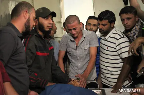 Relatives of 20-year-old Palestinian Yahya Farahat, who was killed by Israeli security forces during clashes in the northern Gaza Strip, mourn over his body at a hospital morgue in Gaza city on October 16, 2015. The unre...