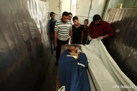 Relatives of 20-year-old Palestinian Yahya Farahat, who was killed by Israeli security forces during clashes in the northern Gaza Strip, mourn over his body at a hospital morgue in Gaza city on October 16, 2015. The unre...