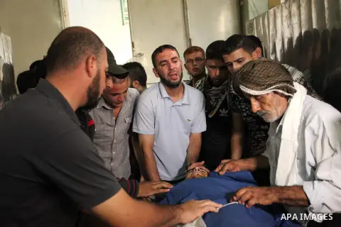 Relatives of 20-year-old Palestinian Yahya Farahat, who was killed by Israeli security forces during clashes in the northern Gaza Strip, mourn over his body at a hospital morgue in Gaza city on October 16, 2015. The unre...