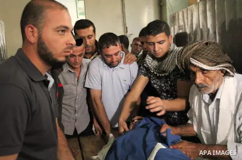 Relatives of 20-year-old Palestinian Yahya Farahat, who was killed by Israeli security forces during clashes in the northern Gaza Strip, mourn over his body at a hospital morgue in Gaza city on October 16, 2015. The unre...