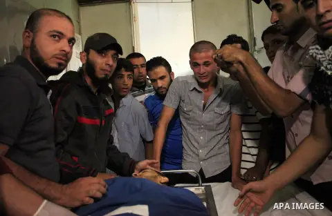 Relatives of 20-year-old Palestinian Yahya Farahat, who was killed by Israeli security forces during clashes in the northern Gaza Strip, mourn over his body at a hospital morgue in Gaza city on October 16, 2015. The unre...