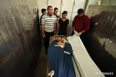 Relatives of 20-year-old Palestinian Yahya Farahat, who was killed by Israeli security forces during clashes in the northern Gaza Strip, mourn over his body at a hospital morgue in Gaza city on October 16, 2015. The unre...