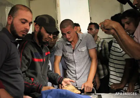 Relatives of 20-year-old Palestinian Yahya Farahat, who was killed by Israeli security forces during clashes in the northern Gaza Strip, mourn over his body at a hospital morgue in Gaza city on October 16, 2015. The unre...