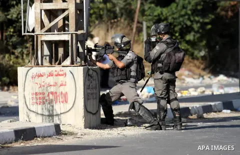 Members of Israeli security forces aim at Palestinian protesters during clashes at the Israeli Hawara checkpoint near the West Bank city of Nablus October 16, 2015. The unrest that has engulfed Jerusalem and the occupied...