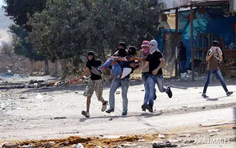 Palestinian protester carry an injured comrade during clashes with Israeli security forces at the Israeli Hawara checkpoint near the West Bank city of Nablus October 16, 2015. The unrest that has engulfed Jerusalem and t...