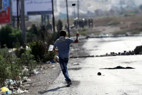A Palestinian protester throws stones towards Israeli security forces during clashes at the Israeli Hawara checkpoint near the West Bank city of Nablus October 16, 2015. The unrest that has engulfed Jerusalem and the occ...