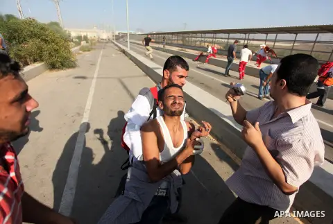 Palestinian protester help an injured comrade during clashes with Israeli security forces at the Erez crossing checkpoint in the northern Gaza Strip October 16, 2015. The unrest that has engulfed Jerusalem and the occupi...