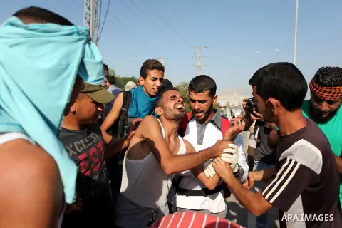 Palestinian protester help an injured comrade during clashes with Israeli security forces at the Erez crossing checkpoint in the northern Gaza Strip October 16, 2015. The unrest that has engulfed Jerusalem and the occupi...