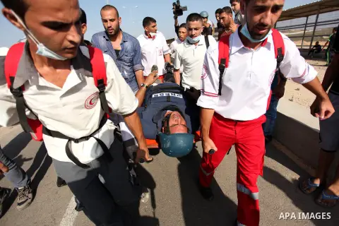 Palestinian medics carry an injured journalist during clashes between Palestinian protesters and Israeli security forces at the Erez crossing checkpoint in the northern Gaza Strip October 16, 2015. The unrest that has en...