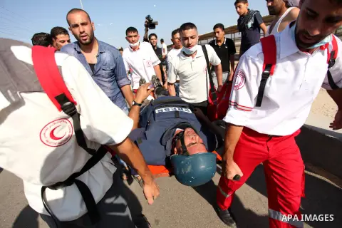 Palestinian medics carry an injured journalist during clashes between Palestinian protesters and Israeli security forces at the Erez crossing checkpoint in the northern Gaza Strip October 16, 2015. The unrest that has en...
