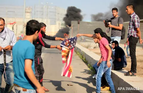 A Palestinian protester burns U.S flag during clashes with Israeli security forces at the Erez crossing checkpoint in the northern Gaza Strip October 16, 2015. The unrest that has engulfed Jerusalem and the occupied West...