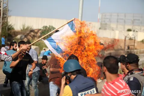 A Palestinian protester burns Israeli flag during clashes with Israeli security forces at the Erez crossing checkpoint in the northern Gaza Strip October 16, 2015. The unrest that has engulfed Jerusalem and the occupied...