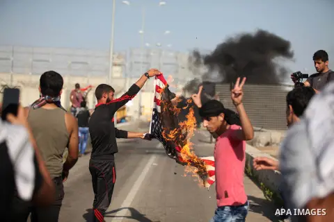 A Palestinian protester burns U.S flag during clashes with Israeli security forces at the Erez crossing checkpoint in the northern Gaza Strip October 16, 2015. The unrest that has engulfed Jerusalem and the occupied West...