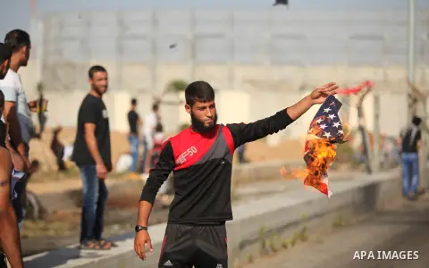 A Palestinian protester burns U.S flag during clashes with Israeli security forces at the Erez crossing checkpoint in the northern Gaza Strip October 16, 2015. The unrest that has engulfed Jerusalem and the occupied West...