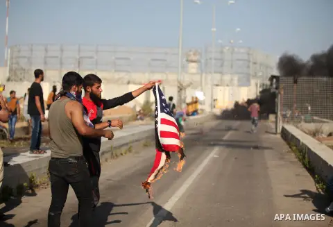 A Palestinian protester burns U.S flag during clashes with Israeli security forces at the Erez crossing checkpoint in the northern Gaza Strip October 16, 2015. The unrest that has engulfed Jerusalem and the occupied West...