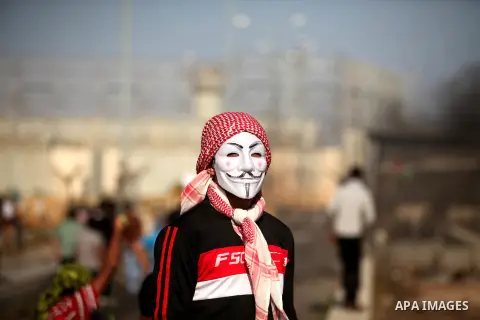 A masked Palestinian proterster looks on during clashes with Israeli security forces at the Erez crossing checkpoint in the northern Gaza Strip October 16, 2015. The unrest that has engulfed Jerusalem and the occupied We...